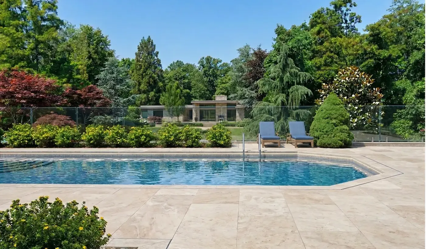 Person holding a smartphone on a video call next to a pool fence during a remote inspection